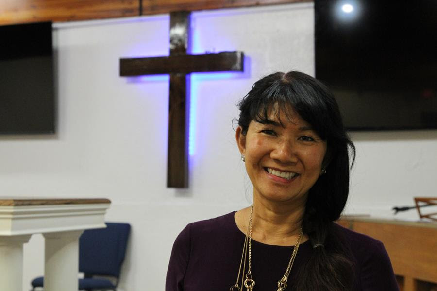 In this May 24, 2021, photo, Linda Dunegan poses for a photo in the sanctuary of the Open Door Baptist Church in Anchorage, Alaska. Dunegan purchased a former strip club and leased the main floor to the church.