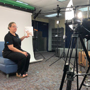 Woman reading a book in front of camera