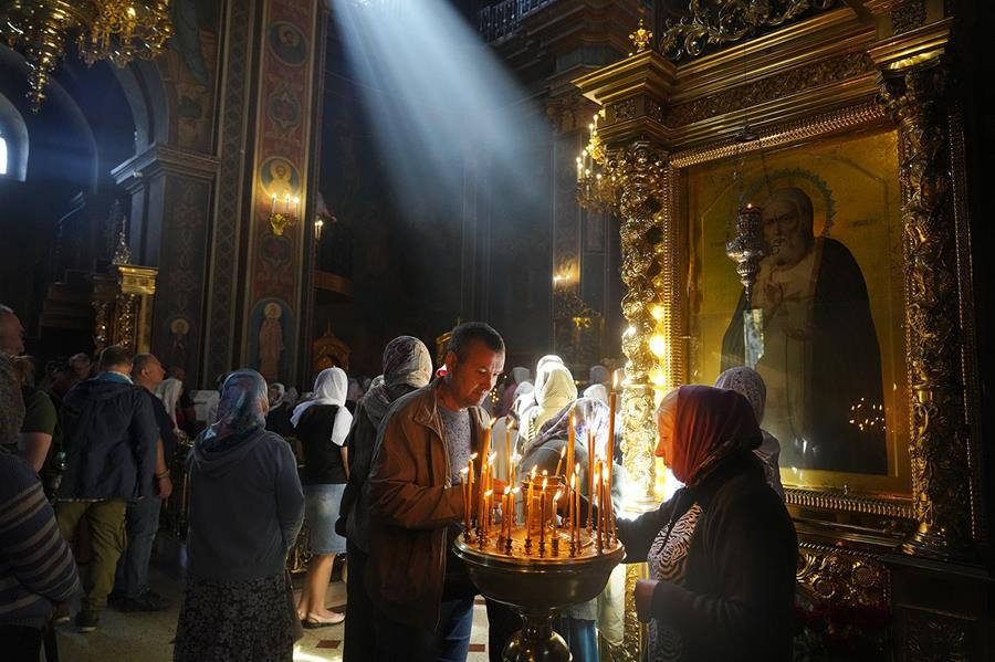 People gather in an Orthodox church in Ukraine to light candles in memory of people that were killed by Russian shelling.