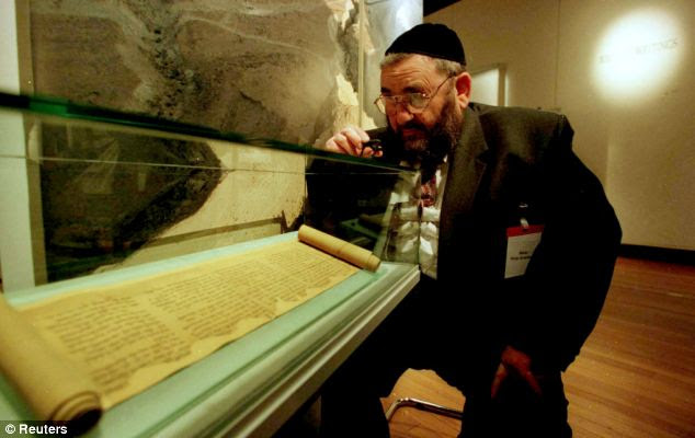 A Rabbi studies one of the 'Scrolls from the Dead Sea' on display in Glasgow. now the family that discovered them is set to sell more 'fragments' to collectors