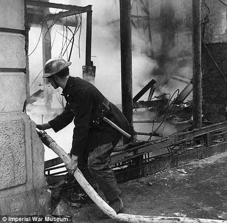All hands to the pump: A fireman dampens down flames in a bombed building during the Blitz in London in 1940. Four years later, Beaton photographed the Chinese Police force grouped in a circular doorway at headquarters in Chengtu