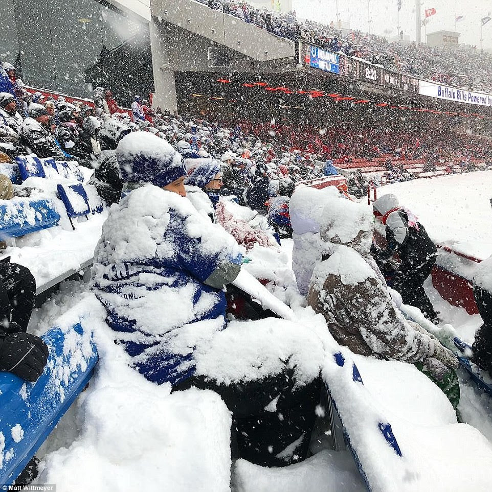 Photo of football fans covered in snow.