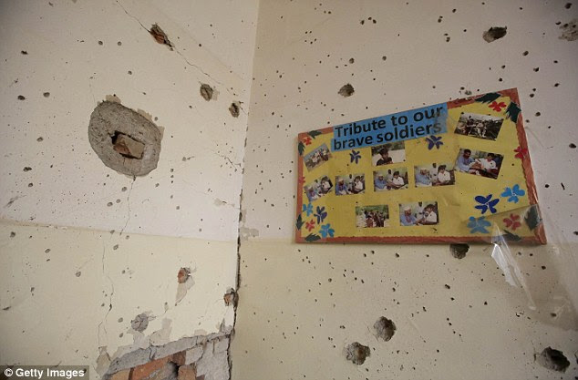 Bullet holes have punctured the plaster of a wall in a classroom, where children died in a hail of gunfire 