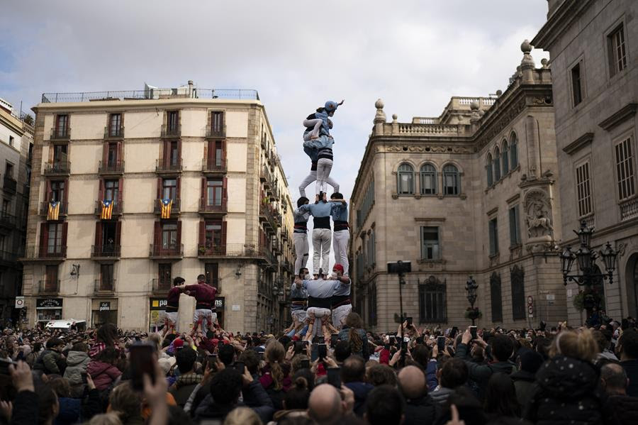 Members of the "Castellers de Poble Sec" complete their human tower during the Saint Eulàlia fesitivities in Barcelona, Spain, Friday, Feb. 11, 2022.