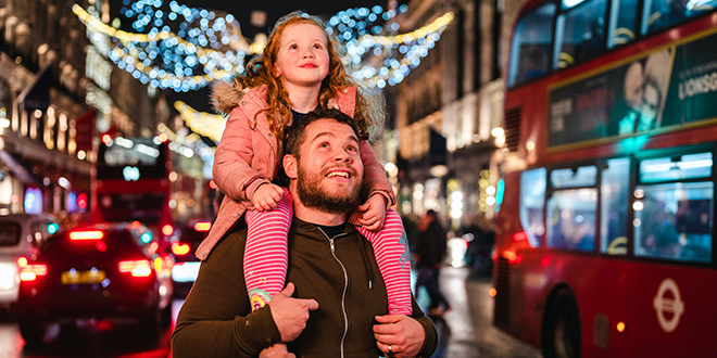 A family admiring the Christmas lights in Regent street. Image: © visitlondon/Peter Kindersley.