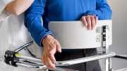 A health care worker helps a client with a walker