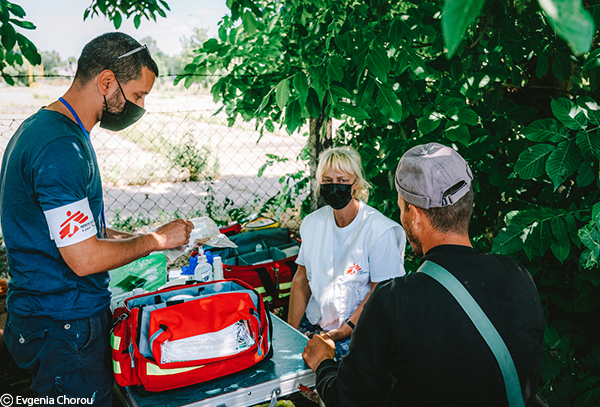 Un mediador cultural de MSF junto con una enfermera explican a un paciente cómo usar un kit para heridas durante una consulta médica de la clínica móvil de MSF en el cruce fronterizo de Horgos 2 en Serbia. 