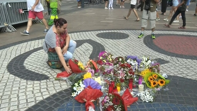 Una dona posa flors damunt del mosaic de Joan Miró