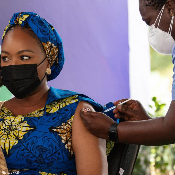 Photo of a Black woman receiving a dose of the COVID-19 vaccine.