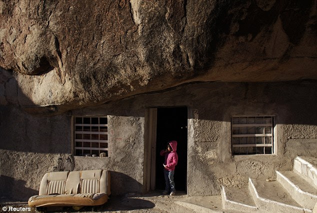Family: Lucero Hernandez, Benito's granddaughter, stands in the doorway of the family's unusual home with a 131-foot rock used as a roof