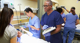 doctors and nurses treating several patients in emergency room