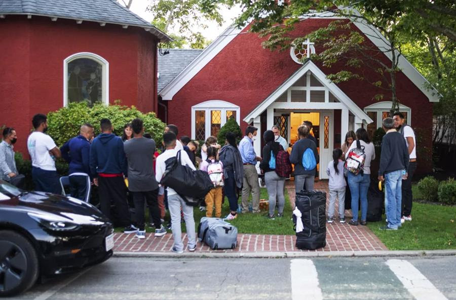 Immigrants gather with their belongings outside St. Andrew’s Episcopal Church, Sept. 14, 2022, in Edgartown, Massachusetts, on Martha’s Vineyard.