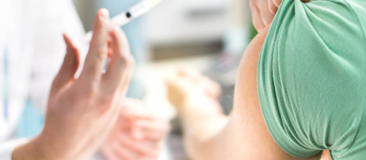 Doctor giving flu shot to person