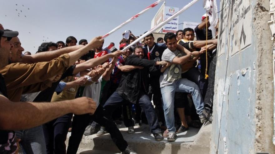 Manifestantes iraquíes en 2011 tratando de derribar un muro de la Zona Verde controlada por EEUU. En la misma época en Siria estallaban las revueltas