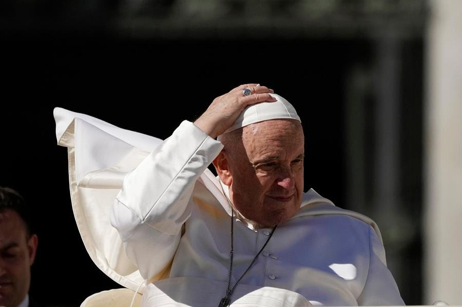 Pope Francis adjusts his skull cap.