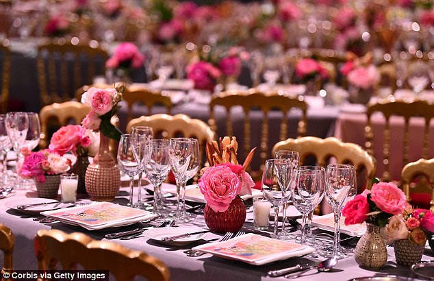 Elegante: As longas mesas foram decoradas com frascos de flores rosa vibrantes, retratadas