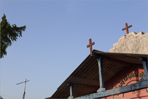 Three crosses from different locations are accented by a blue sky.
