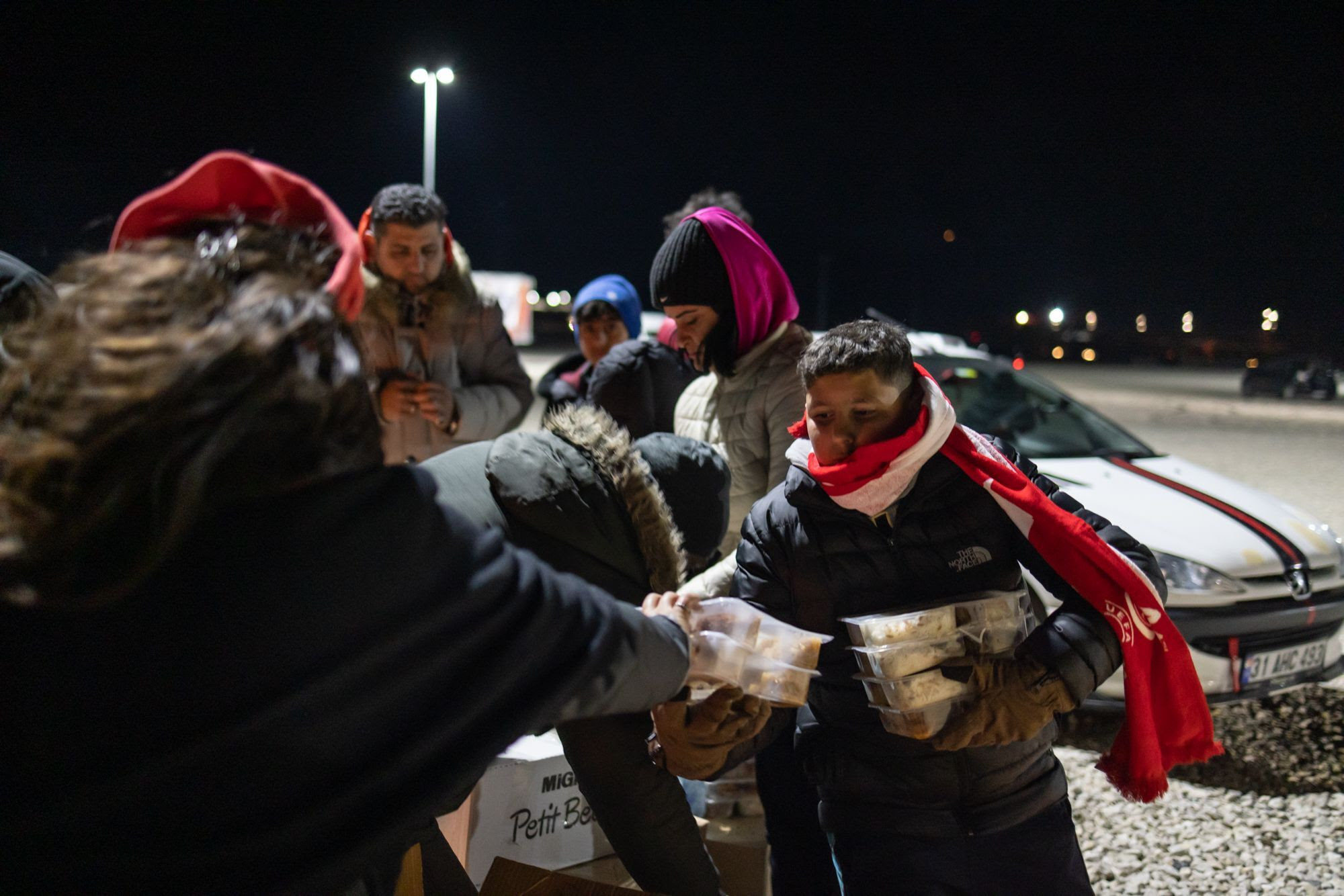 WCK team handing out meals to families in Türkiye at nighttime.