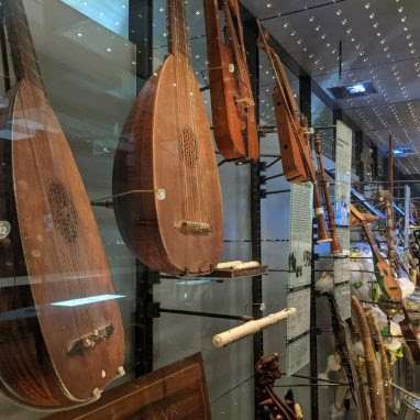 Two lutes and other instruments in a glass display case