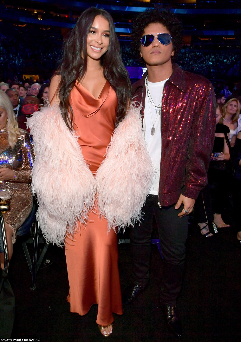 Color mis-coordination: Model Jessica Caban's feather wrap totally clashed with her orange silk dress - and her longtime boyfriend Bruno Mars' jacket