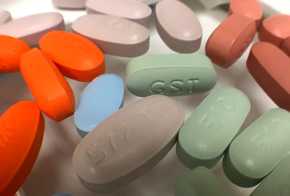 Assorted antiretroviral drug tablets on a white surface