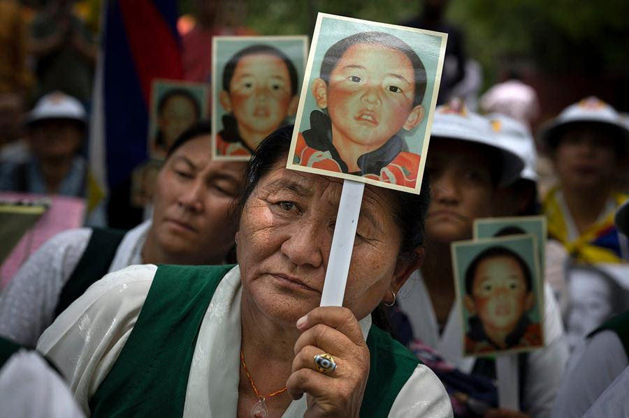 Members of the Tibetan Women's Association hold portraits of the 11th Panchen Lama, Gendhun Choekyi Nyimi.