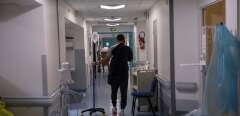 A patient walks along the corridor of the emergency unit of the Saint Camille hospital in Bry-sur-Marne, a suburb of Paris, on January 21, 2022. (Photo by JULIEN DE ROSA / AFP)