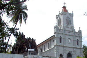 A large, white church with a cross atop of a steeple.