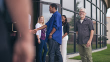 Photo of church greeters shaking hands with visitors