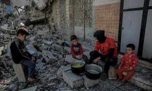  Un hombre cocina comida para sus hijos sobre un fuego de madera frente a su hogar destruido en el barrio de Al-Rimal, al oeste de la Ciudad de Gaza.