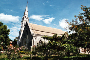 A church building surrounded by trees and bushes.