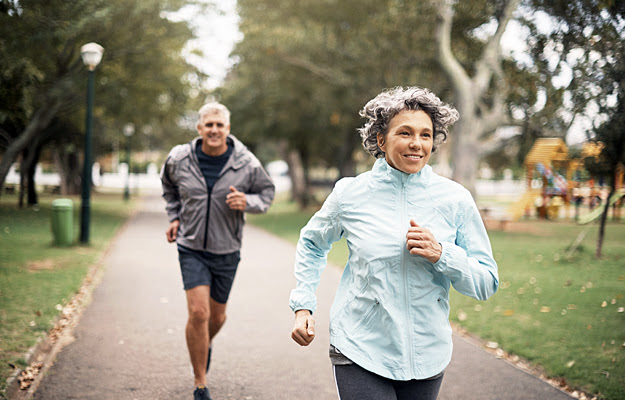 A mature couple jogging outside.