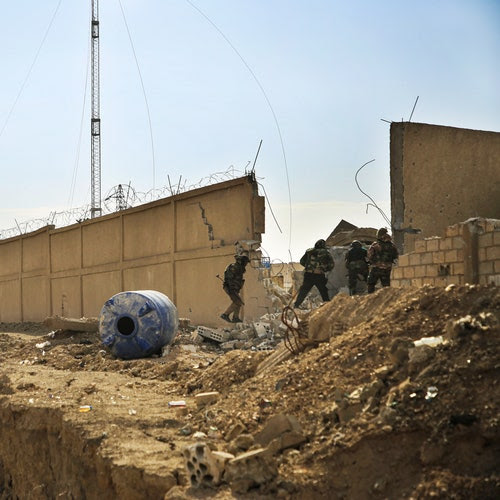 Four Kurdish-led Syrian Democratic Forces fighters take their positions at the defense wall of Gweiran Prison, in Hasakah, northeast Syria.