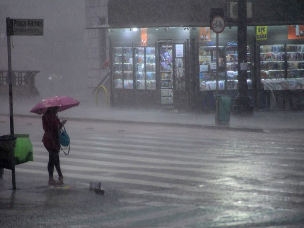 Pedestre enfrenta temporal na Praça Ramos, no centro de São Paulo, na tarde desta segunda-feira (16) (Foto: Cris Faga/Fox Press Photo/Estadão Conteúdo)