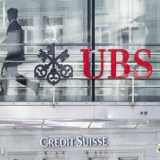 Ein Mann laeuft zwischen den beiden Logos der Banken UBS und Credit Suisse, aufgenommen am Montag, 12. Juni 2023 in Zuerich. Heute verkuendete die nunmehr einzige Schweizer Grossbank in einem offenen Brief: Die Uebernahme der Credit Suisse durch die UBS ist vollzogen. (KEYSTONE/Ennio Leanza)