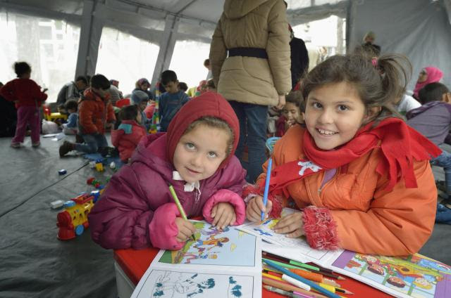 Two girls from Afghanistan colour in a refugee centre in Serbia. 