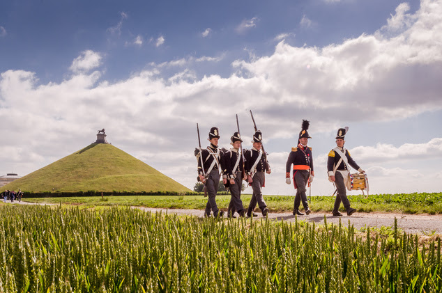 In this June 9, 2015, fie photo, Battle of Waterloo re-enactors walk near the Lion's Mound during a historical walk for journalists in Braine-l'Alleud, near ...