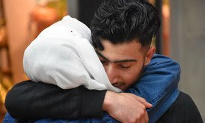 Un adolescente sirio se reúne con su familia en un aeropuerto de Alemania.