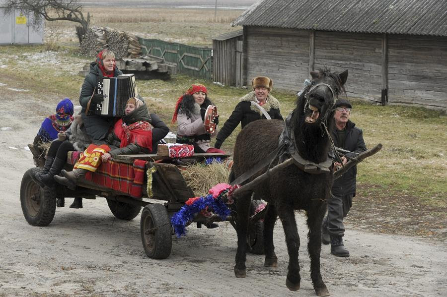 Actors perform during celebration of Orthodox Christmas and a Pull the Kolyada, a Slaviic-Christmas related ritual. They are playing instruments and riding a wagon pulled by a horse.