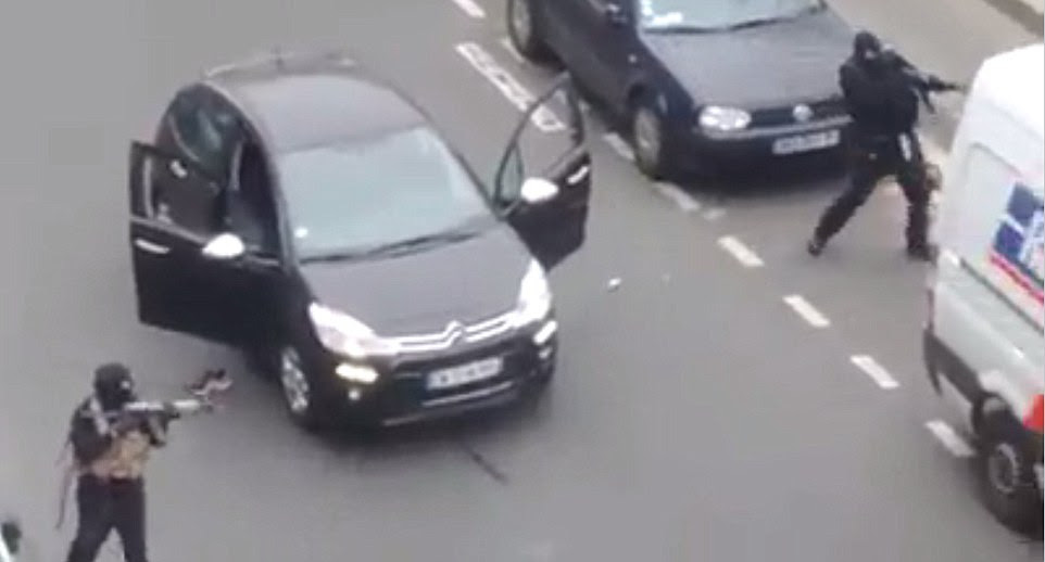 'Massacre': The gunmen are seen brandishing Kalashnikovs as they move in on the injured police officer from their vehicle outside the office