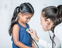 doctor listening to little girl's heart