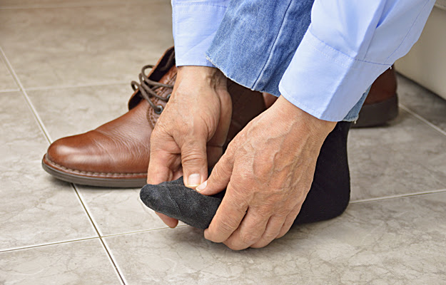 A closeup of a man holding his foot.