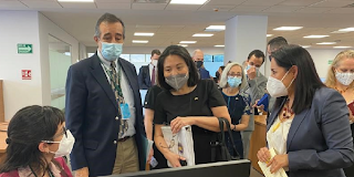 Deputy Secretary Julie Su standing next to the Director of the Federal Center, Dominguez Marrufo, looking at a worker's computer screen.