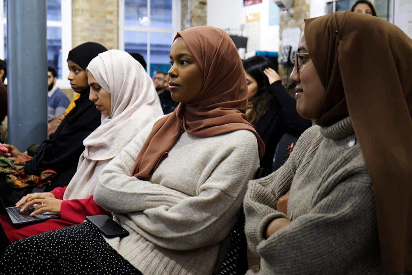 An image of Muslim women sitting together in a large room.