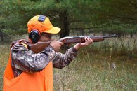 hunter dressed in blaze orange with ear protection
