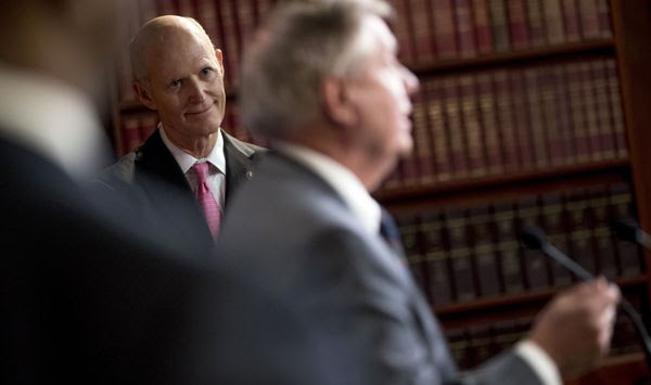 Sen. Rick Scott, R-Fla., left, listens as Sen. Lindsey Graham, R-S.C., left, speaks at a news conference about the coronavirus relief bill on Capitol Hill in Washington, Wednesday, March 25, 2020. Senators discussed what they are calling a &quot;drafting error&quot; in the 2 trillion dollar stimulus bill expected to be voted on today in the Senate. (AP Photo/Andrew Harnik)