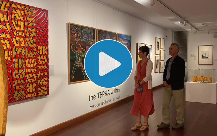 Photo of a man and woman at the Shoalhaven Regional Gallery looking at artworks from the TERRA within exhibition