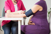 Health professional measuring woman's blood pressure