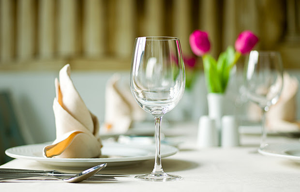 An empty wine glass on a restaurant table.