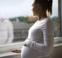 Pregnant woman looking out a window